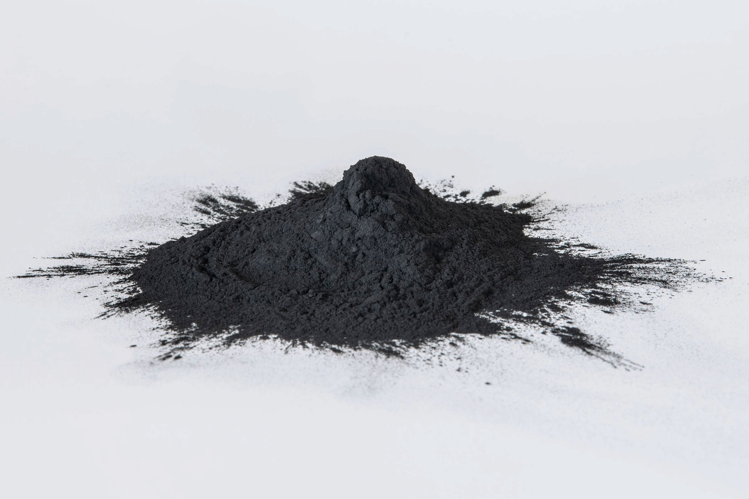 Pile of black clay charcoal powder on a white background