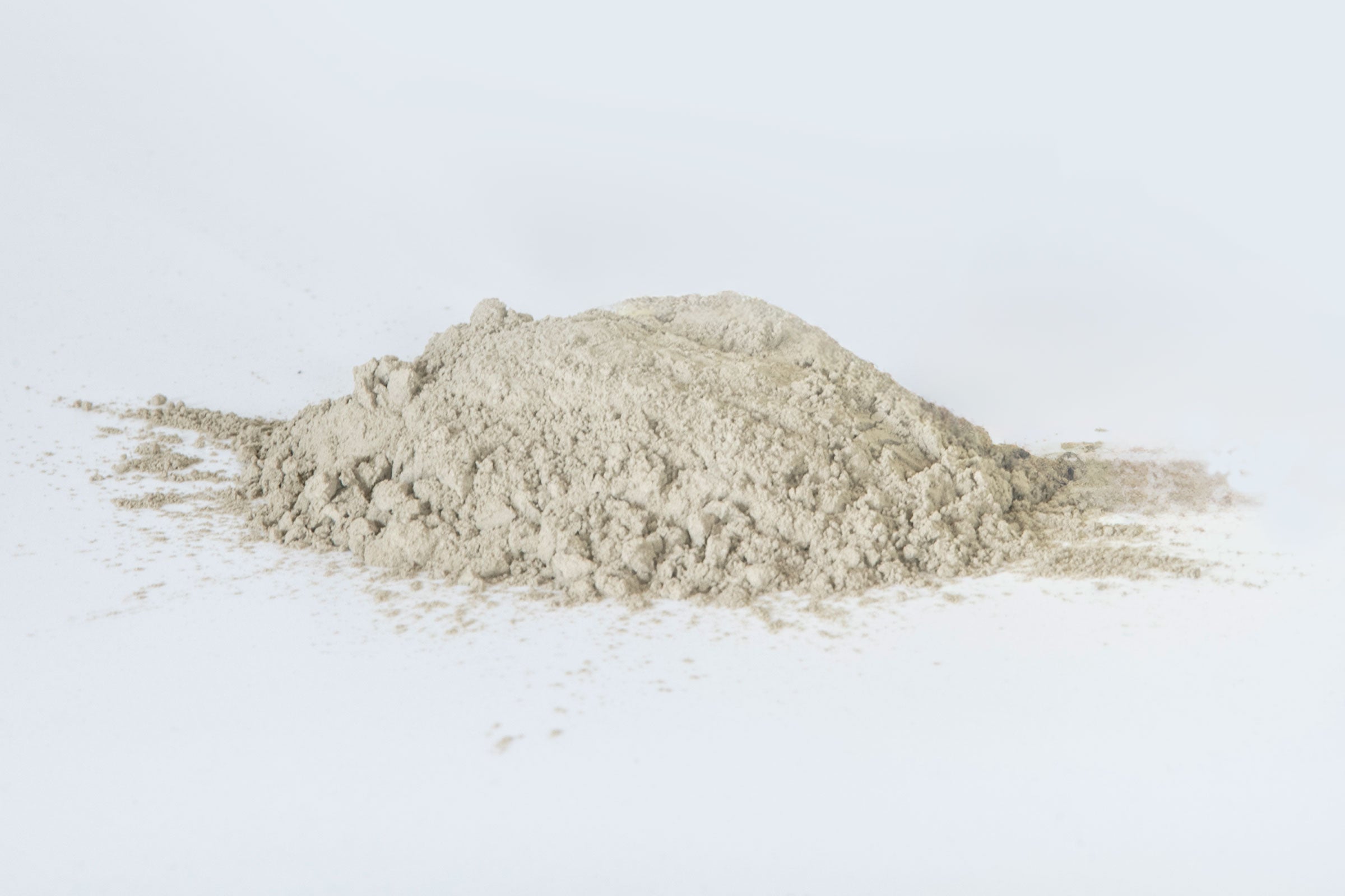 Pile of light brown powder on a white background