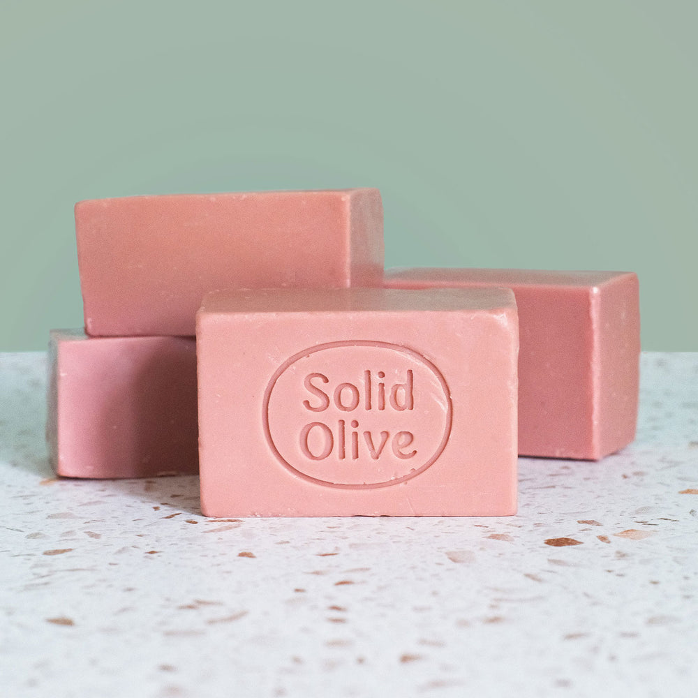 Bar of soap on a textured surface with a purple background
