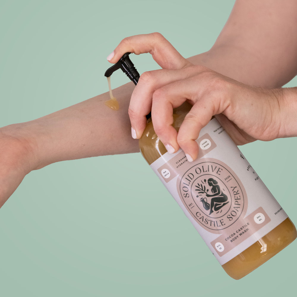 Solid Olive & Castle Soapery body wash bottle on a textured surface with a purple background