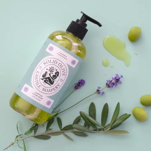 Bottle of solid olive soap with olive leaves and flowers on a light green background