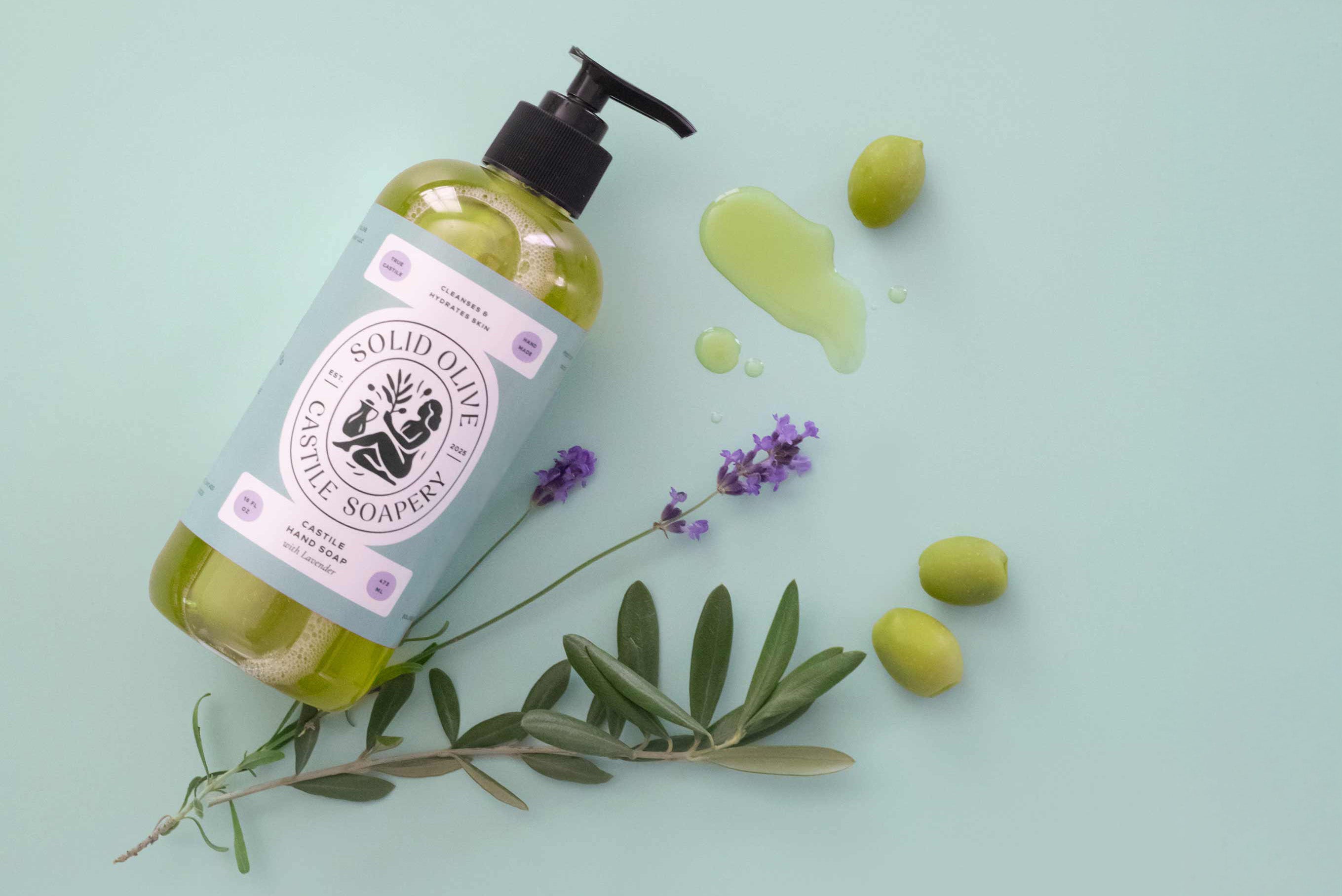 Solid Olive Gentle Soapers bottle with olive leaves and olives on a light green background