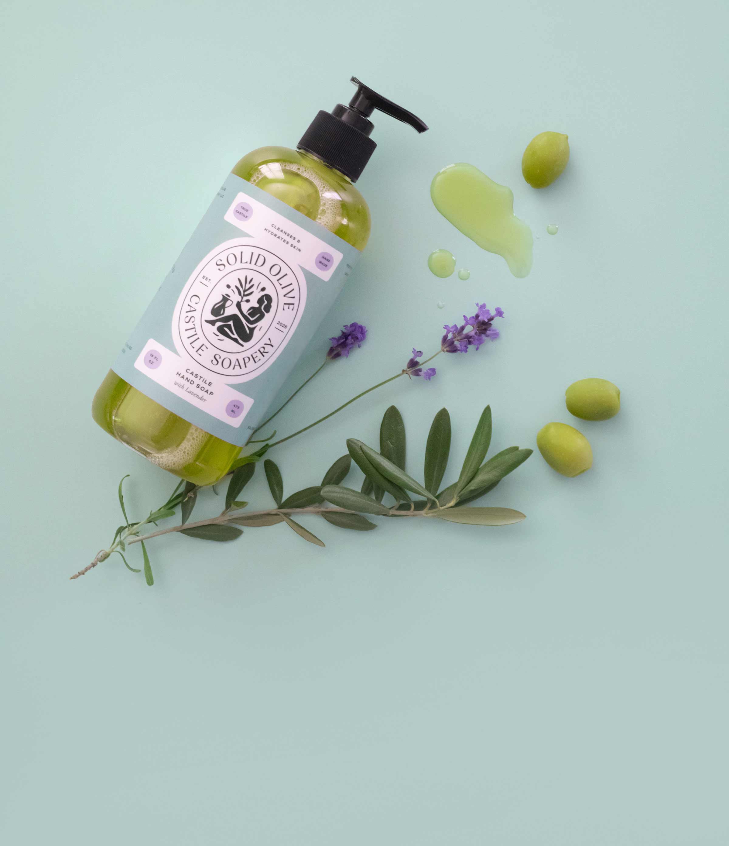 Solid olive soap bottle with green olives and lavender on a light blue background