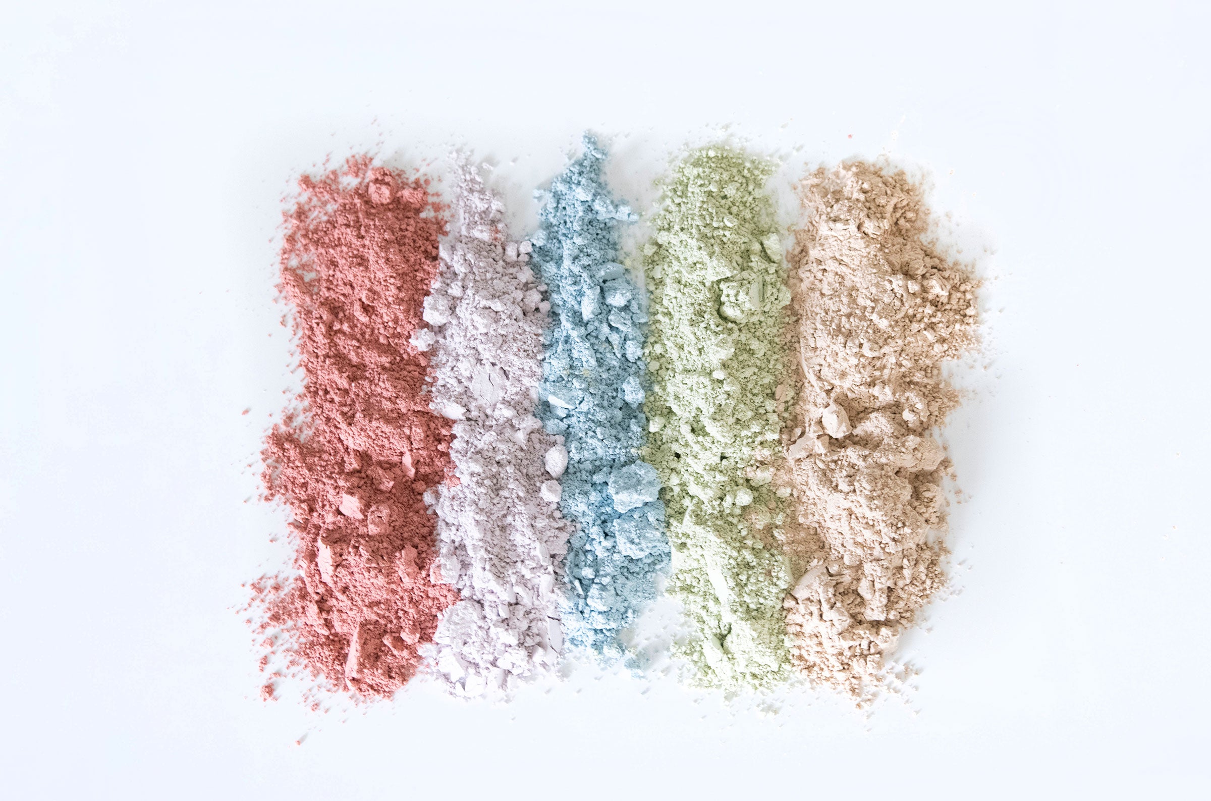 Four piles of colorful clays in red, blue, green, and beige on a white background