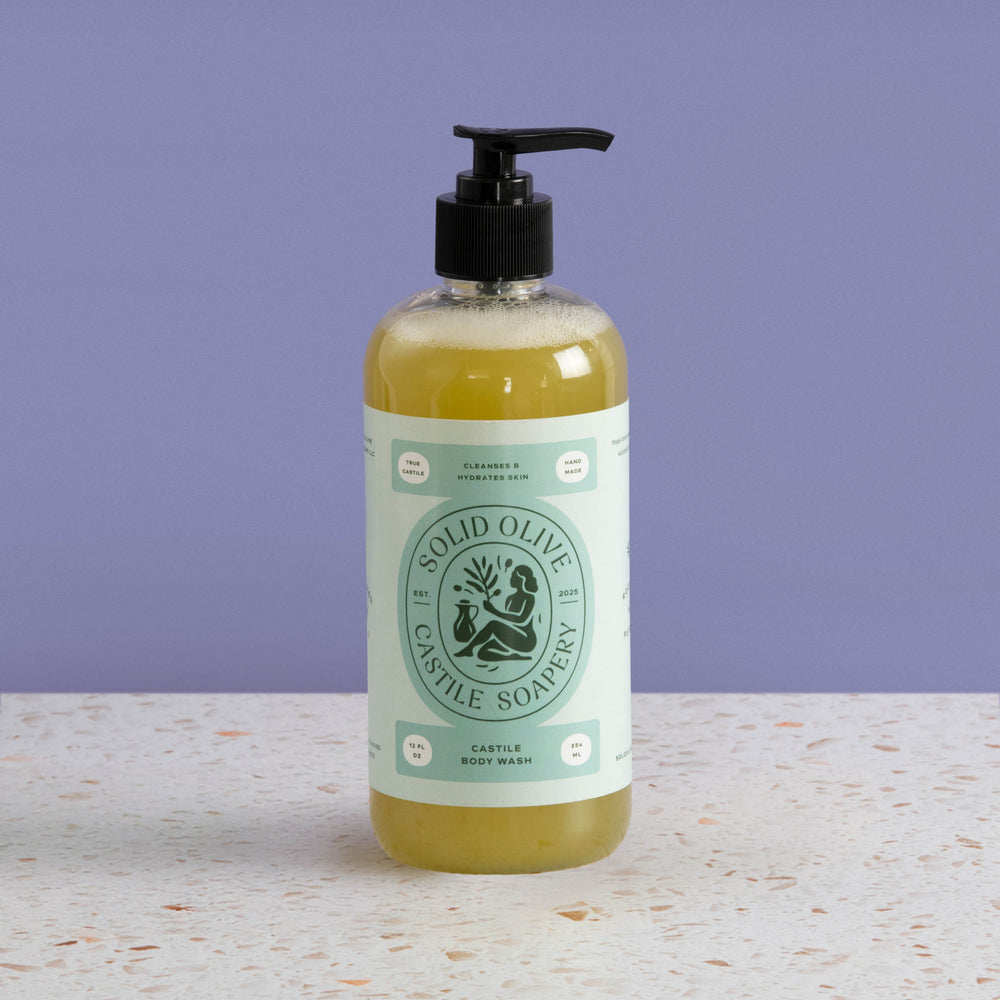 Bottle of Solid Olive & Castile Soapery body wash on a light surface with a purple background
