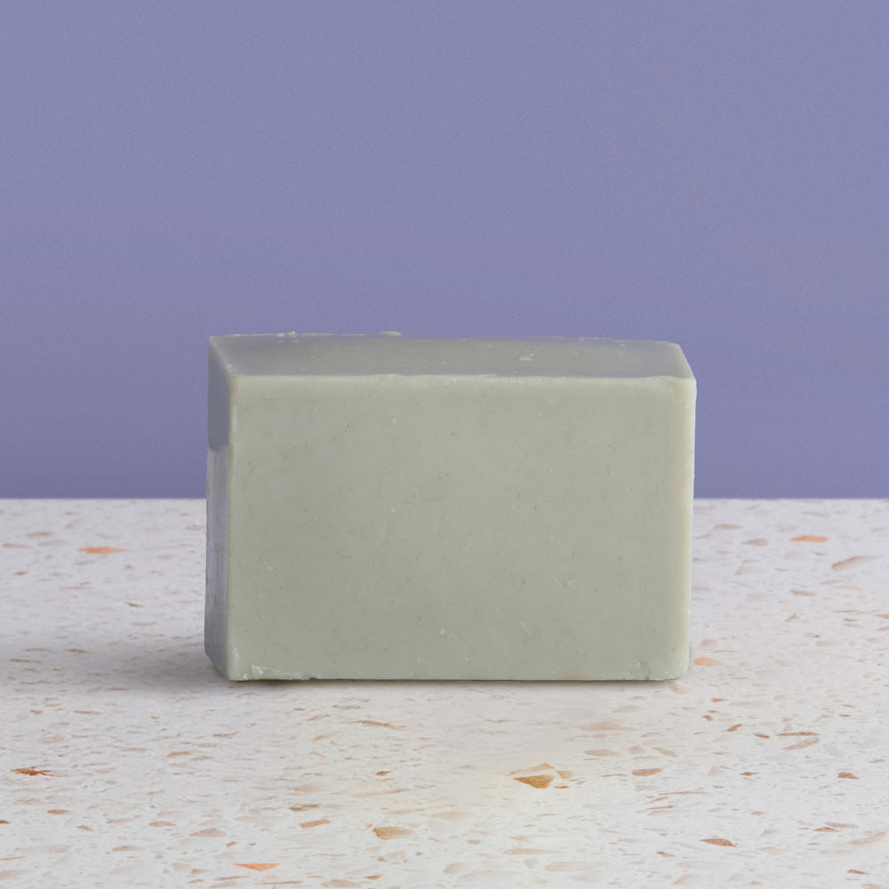 Dead sea  soap bar on a textured surface with a purple background
