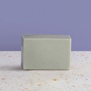 Dead sea  soap bar on a textured surface with a purple background
