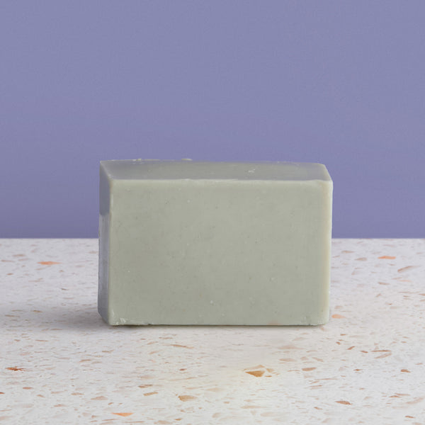 Dead sea  soap bar on a textured surface with a purple background