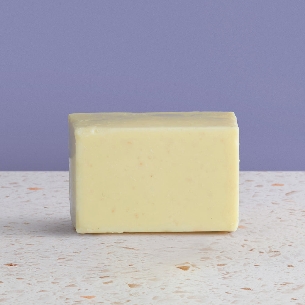 Bar of  sea salt soap on a textured surface with a purple background