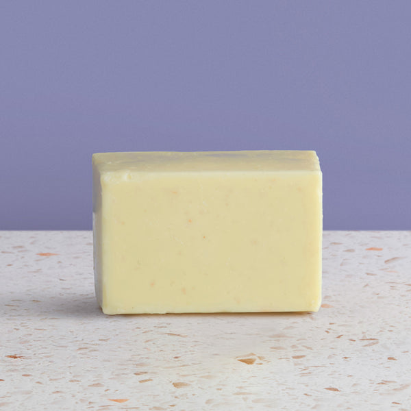 Bar of  sea salt soap on a textured surface with a purple background