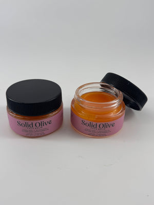 Solid Olive 0.5 oz Face Balm in glass jars, with one jar open